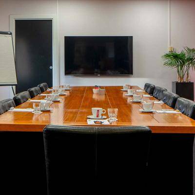 Vergaderruimte met tafel stoelen scherm flip-over en rode muur