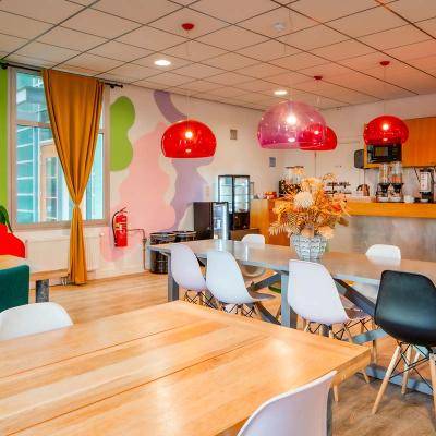 Ontbijtruimte met gekleurde lampen tafels stoelen en kleur op de muur