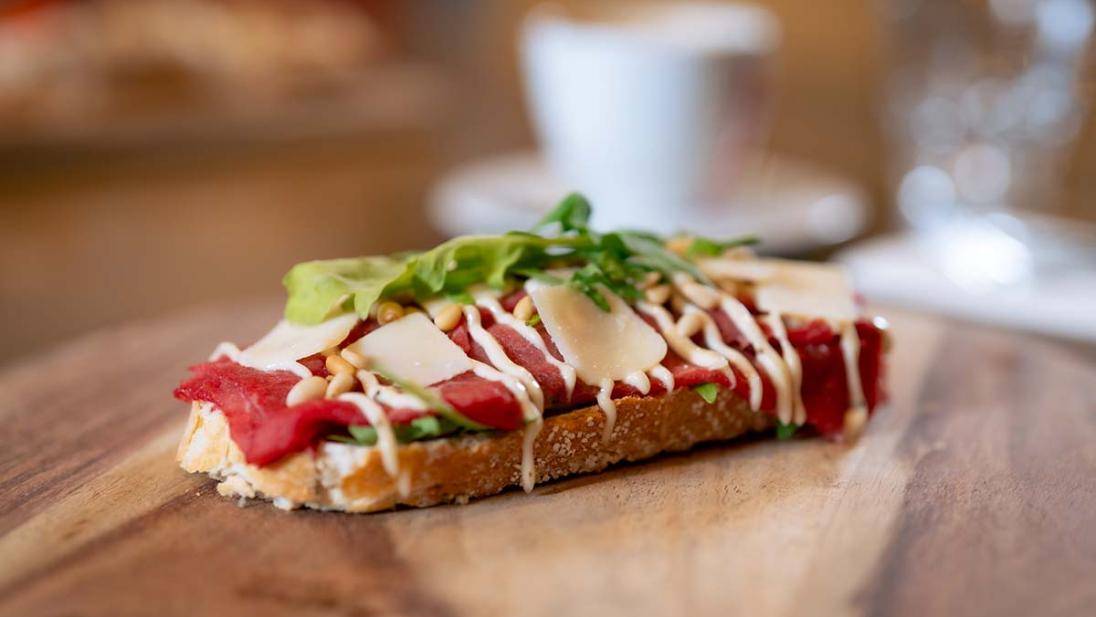 Een broodplank met een broodje carpaccio