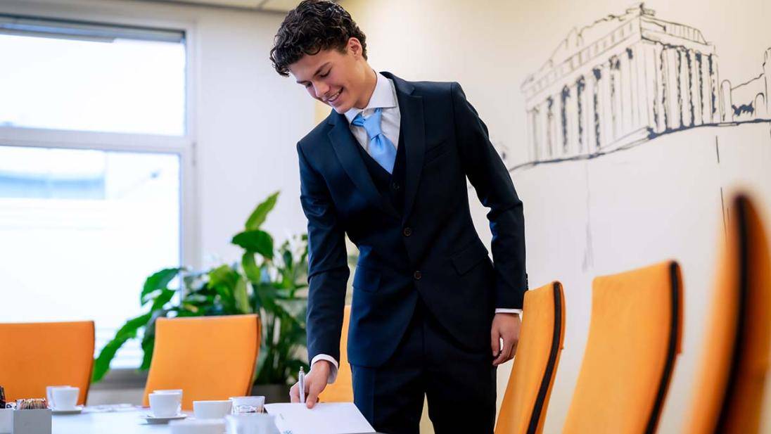Student bereidt vergaderingen voor en legt schrijfblok neer op vergadertafel