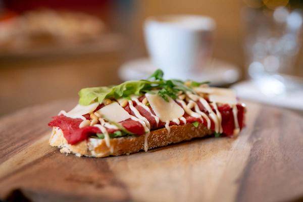 Een broodplank met een broodje carpaccio